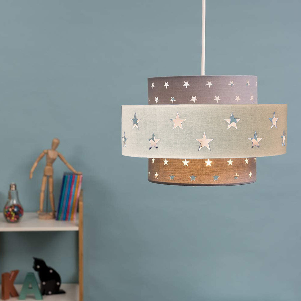 Our Grey and Cream two tiered star shade features a mixture of large and small sweet stars cut out across a grey and cream background. When your lamp is turned on it will shine out through these cut-outs, mimicking a beautiful night sky. This lampshade is made with soft-touch fabric for a little bit of luxury.